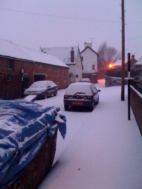 snow on cars and a road